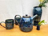 Tofino teapot, mugs and vase by Matthew Freed on a wooden table